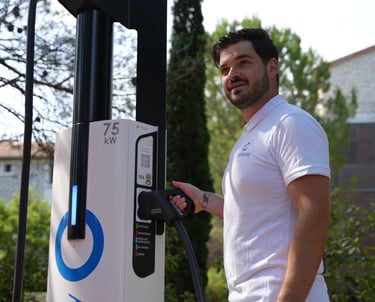 Employé devant une station de recharge électrique