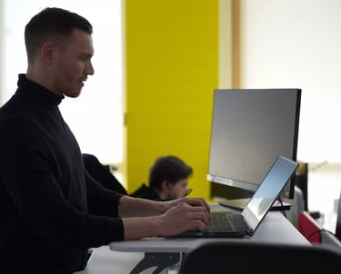 Salarié debout travaillant sur son ordinateur dans l'open space