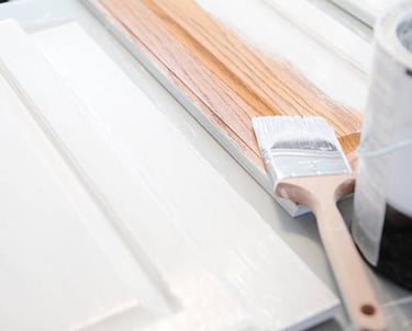 a paintbrush brush an can with cabinet doors