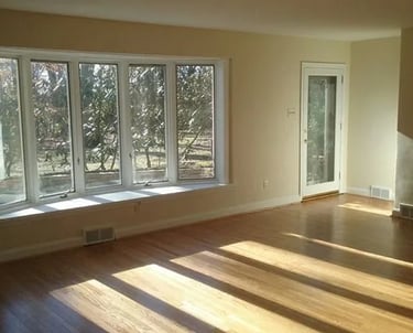 A finished interior painting job room with a window and a large window