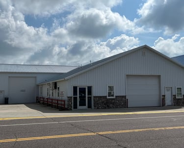 photo of front of building with 2 large garage doors and 2 entry doors