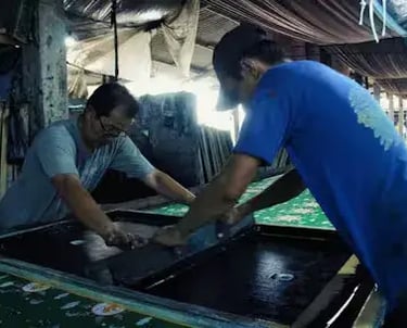 two men are working on a large screen