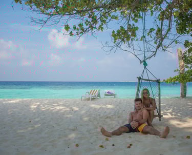 a man and a woman sitting on a beach