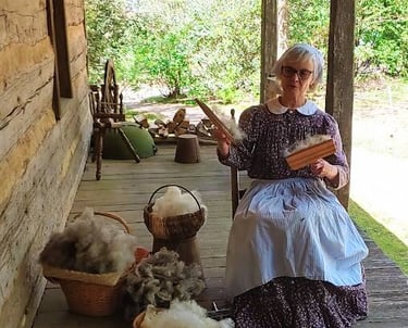 Huntsville, AL - Living history: a lady combs wool to detangle it before spinning