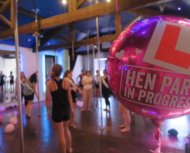 Image of a hen party balloon in the foreground with a group of people using the Sxefit facilities 