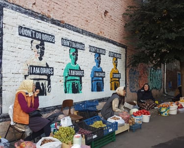 Street photography of woman in Ukraine in front of street art in a market