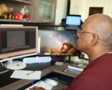 Professional editor working at a modern workstation with multiple monitors and video editing software.