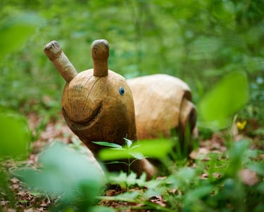 a wooden toy elephant in the woods