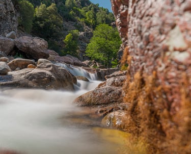 a stream of water flowing over rocks in a canyon