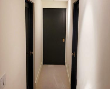 a hallway with a black door and a black door