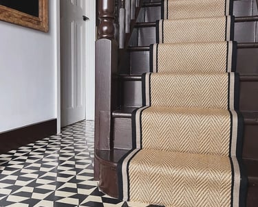 a staircase with a black and white carpet and a black and white carpet