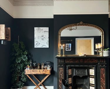 Elegant living room featuring a black marble fireplace, gold arched mirror, and dark charcoal walls.