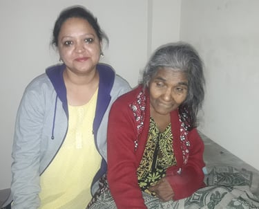 a woman sitting on a bed with an old woman