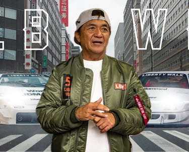 un homme se touchant les mains devant deux voitures dans une rue avec les lettres "LB WK"
