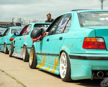 a man in a helmet is sitting in a row of parked cars
