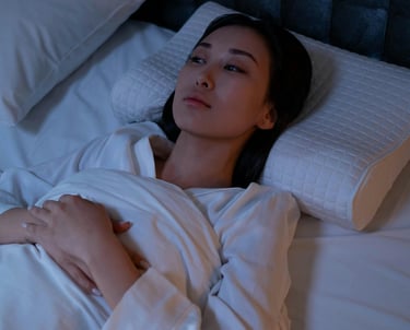 lady lying awake in bed looking fed up and tired. She can't sleep and wants to sleep.