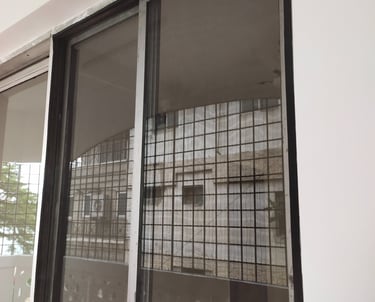 Wide shot of a spacious balcony in Whitefield fitted with a secure white velcro mosquito net.
