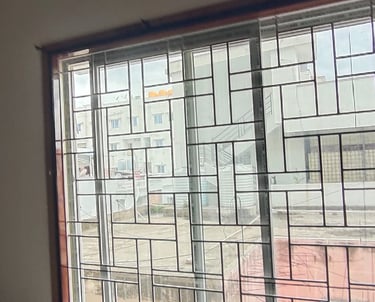 Close-up of a neatly installed velcro mosquito net on a balcony window in a Whitefield apartment.