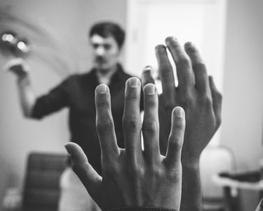 grayscale photo of two university students raising their hand
