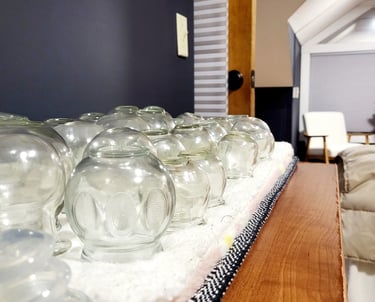 Glass fire cups used for cupping therapy during a customized massage session.