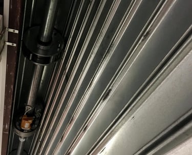 Zoom sur le mécanisme d'enroulement d'un rideau métallique de sécurité pour magasin