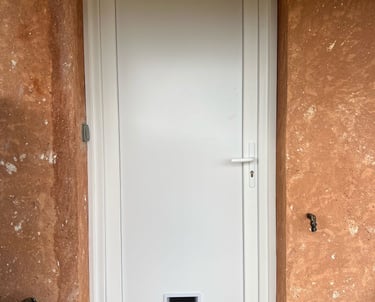 Installation d'une porte d'entrée en PVC blanc avec chatière intégrée par Homestores.
