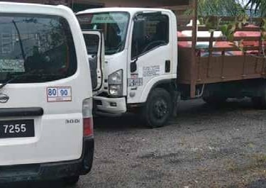 a truck with a trailer parked in front of a house