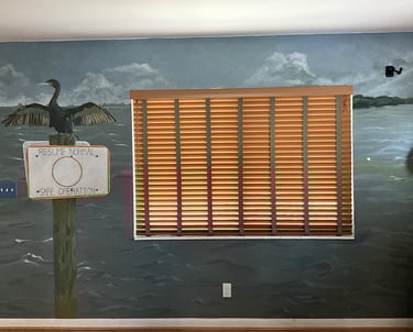 Wall mural of Ft. DeSoto, waterway sign, and cormorant in an office. 