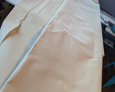 10 oz linen folded and laid on a large artist's table for folding and pinning., 