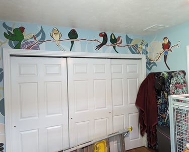 Painting a parrot mural on a large wall with a closet door.