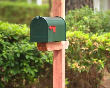 Green mailbox on cedar post