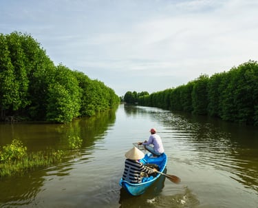 a man in a canoe on a river - SEMATA INDONESIA Program
