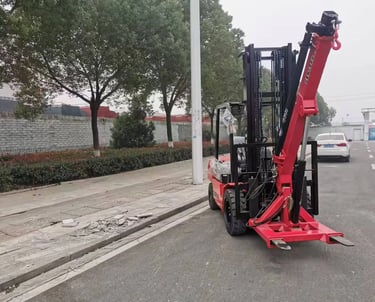 Our CC55 forklift crane attachment on a customer's red forklift. A practical forklift jib crane solution, shown outdoors.