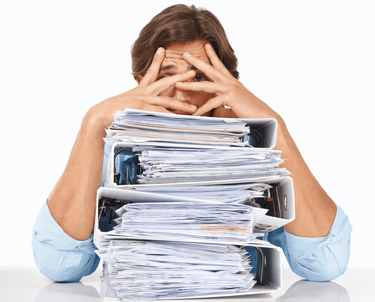 Stressed businessman overwhelmed with piles of paperwork, highlighting the need for an efficient IT solution to streamline op