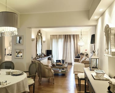 Elegant open plan living and dining room with classic furniture, crystal chandeliers, and neutral decor.