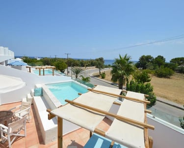 Luxury hotel balcony with a private plunge pool, patio furniture, and scenic ocean views in a tropical resort.