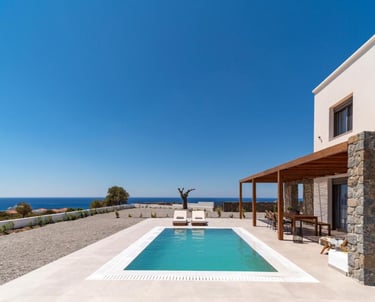 Luxury villa with a private swimming pool and sea view terrace under a clear blue sky.