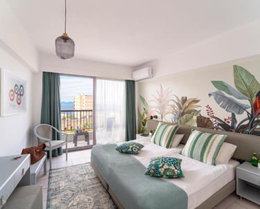 Modern hotel room with a botanical wall mural, private balcony, and tropical decor.