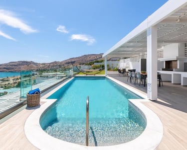 Luxury villa rooftop with infinity swimming pool, outdoor kitchen, and scenic coastal ocean views.