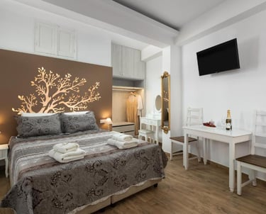 Modern boutique hotel bedroom with a tree wall decal, double bed, and dining area.