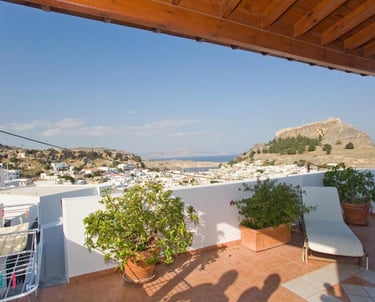 Rooftop terrace overlooking Lindos village and the ancient Acropolis in Rhodes, Greece.