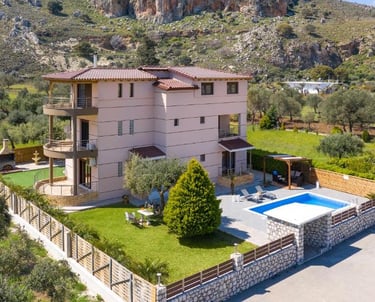 Luxury villa rental with a private swimming pool and garden nestled in a rocky mountain landscape.