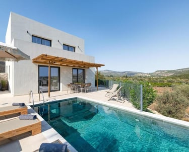 Modern luxury villa with a private infinity pool and patio overlooking a scenic valley landscape.