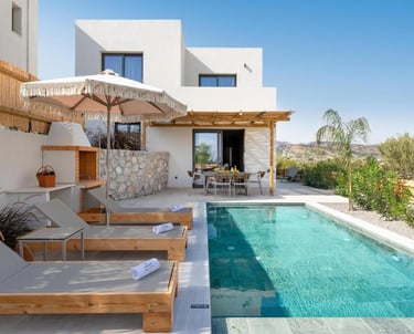 Modern luxury villa with private swimming pool, sun loungers, and outdoor dining patio.