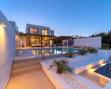 Luxury villa with private pool, outdoor patio, and fire pit at twilight.