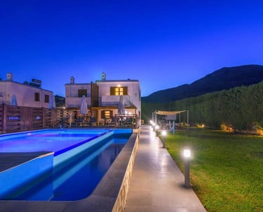Luxury villa rental with private swimming pool and garden at night under a blue sky.
