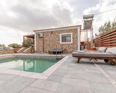 Luxury stone villa rental with private swimming pool and cushioned sun loungers on a modern patio.