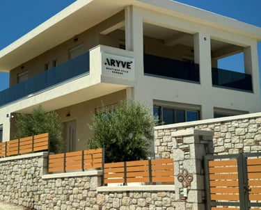 Luxury exterior of Aryve Boutique Villa in Rhodes featuring modern architecture and stone walls.