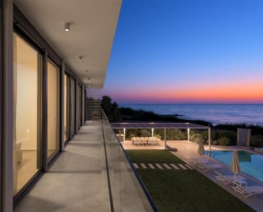 Luxury modern villa balcony with ocean views, swimming pool, and outdoor dining at sunset.