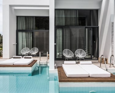 Luxury swim-up hotel rooms with private pool access, sun loungers, and modern terrace furniture.